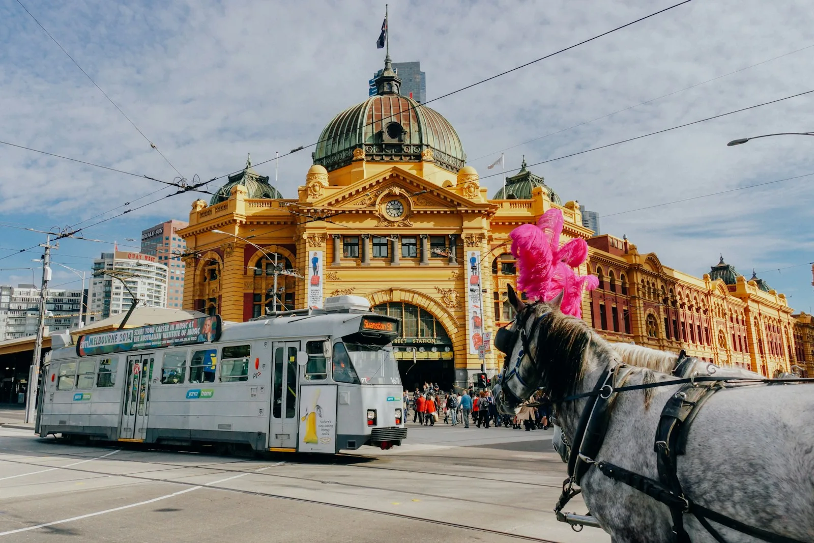 white tram near brown and yellow dome of Flinders Street Station, Melbourne